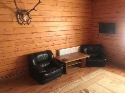 a room with two leather chairs and a wooden table at Elephant in Bachina