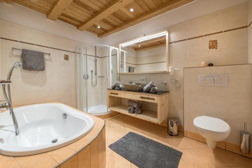 uma casa de banho com uma banheira, um WC e um lavatório. em Kircherhof em Bressanone
