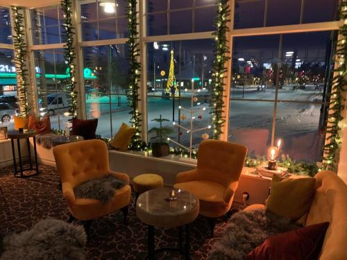 a lobby with chairs and a table and a large window at Orsa Järnvägshotell in Orsa