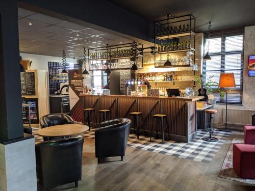 a restaurant with a bar with stools at ibis Saint-Omer Centre in Saint-Omer