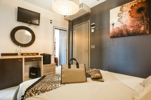 Un dormitorio con una cama con una bolsa. en Hotel Thea & Residence, en Gabicce Mare