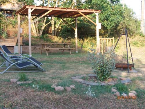 a playground with a swing and a bench in a yard at Gîte de Rouviac in Castelnau-Pégayrols