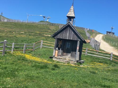 a small building in a field next to a fence at Jagdhütte in Lachtal