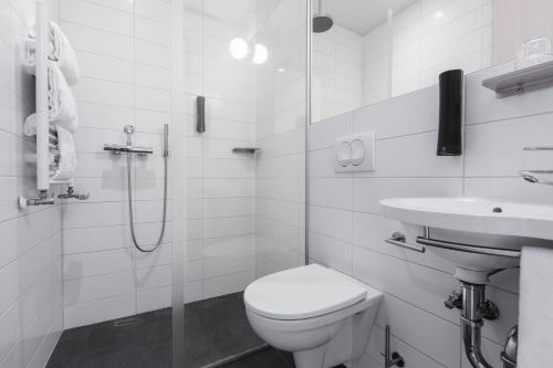 biała łazienka z toaletą i umywalką w obiekcie Reykjavik Lights Hotel by Keahotels w Reykjavík