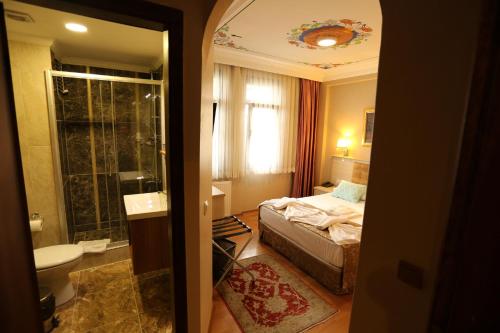 a bedroom with a large bed and a large mirror at Hotel Tashkonak Istanbul in Istanbul