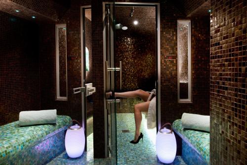 a woman is in a bathroom with a shower at Hotel Residence Henri IV in Paris