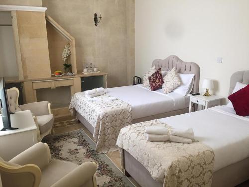 a hotel room with two beds and a chair at Lord's Residence Boutique Hotel in Kyrenia