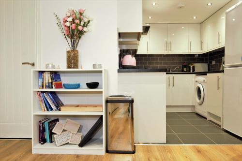a kitchen with white cabinets and a refrigerator at STYLISH 2 BEDROOM APARTMENT IN THE HEART OF GREENWICH in London