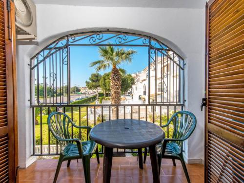 una mesa y sillas en un balcón con vistas a una palmera en Apartment Calas Blancas by Interhome en Torrevieja