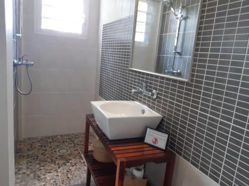 ein Bad mit einem Waschbecken und einem Spiegel in der Unterkunft Suite exotique in L’Étang-Salé