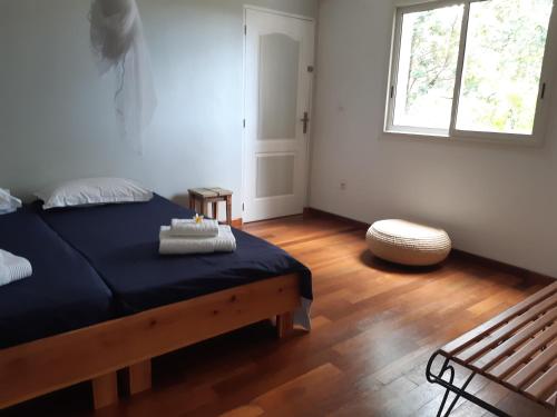 een slaapkamer met een blauw bed en een raam bij Suite exotique in L'Étang-Salé