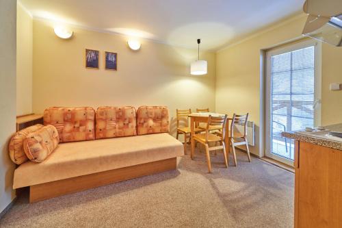 a living room with a couch and a table at Apartmány Penzion Koula in Pec pod Sněžkou