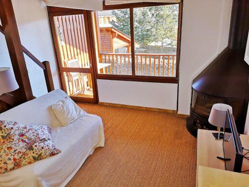 1 dormitorio con cama, TV y balcón en Apartamento actualizado en Caldegas, en Bourg-Madame