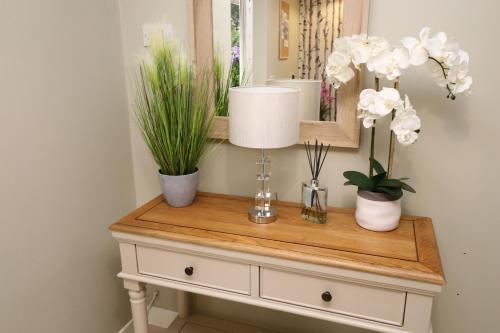 a table with potted plants and a mirror on it at The Spinney in Bracknell