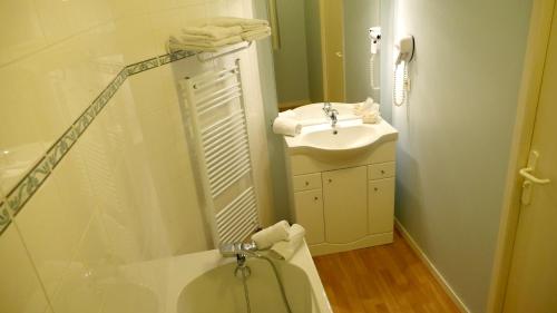 y baño con lavabo, aseo y ducha. en HOTEL Restaurant LE CALDERO, en Montpon-Ménestérol