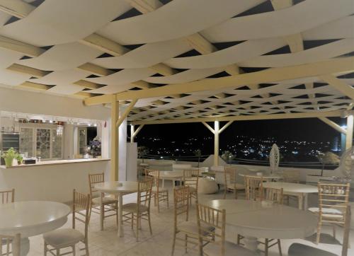 a dining area with tables, chairs and umbrellas at The White Suites in Adamantas