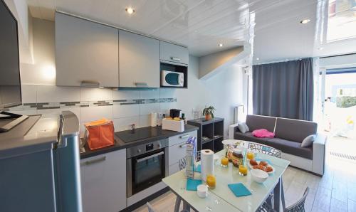 une cuisine avec des armoires blanches et une table dans une pièce dans l'établissement Village de Cromenach, à Ambon