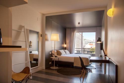 ein Hotelzimmer mit einem Bett und einem Fenster in der Unterkunft Sixties Ramblas in Barcelona