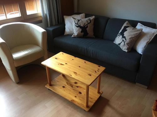 salon z niebieską kanapą i drewnianym stolikiem kawowym w obiekcie Apartment Butterfly by Interhome w mieście Adelboden