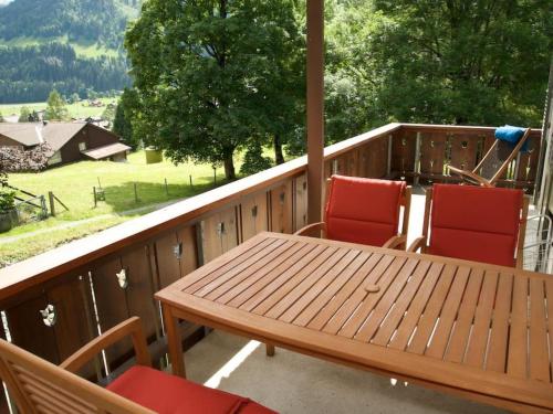 - une table et des chaises en bois sur une terrasse couverte avec vue dans l'établissement Apartment Pony 4-Bettwohnung by Interhome, à Lenk im Simmental