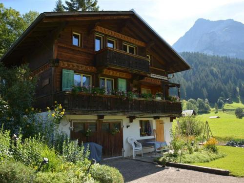 ein großes Holzhaus mit Balkon darüber in der Unterkunft Apartment Sonnegg by Interhome in Gsteig