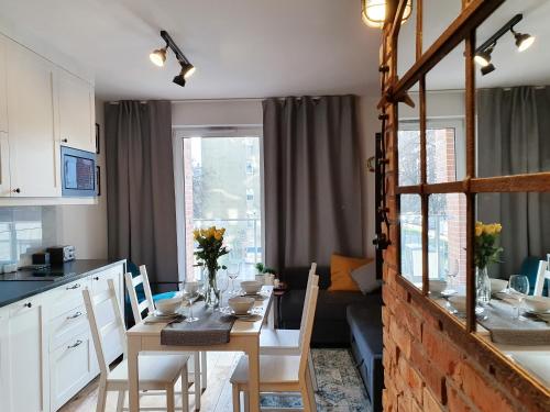 een keuken en eetkamer met een tafel met stoelen en een eetkamer bij Apartamenty NAUTICA Gdańsk in Gdańsk