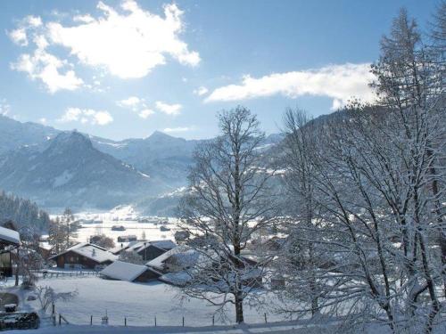 un village recouvert de neige avec des montagnes en arrière-plan dans l'établissement Apartment Pony 4-Bettwohnung by Interhome, à Lenk im Simmental