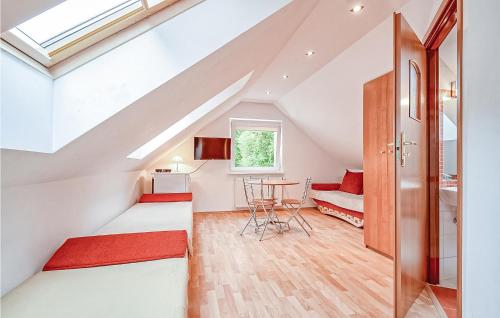 a attic room with a staircase with red accents at Awesome Home In Grzybowo With 3 Bedrooms And Internet in Grzybowo