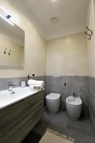 a bathroom with a sink and a toilet and a mirror at Napoli Vesuvio Apartments by Dimorra in Naples