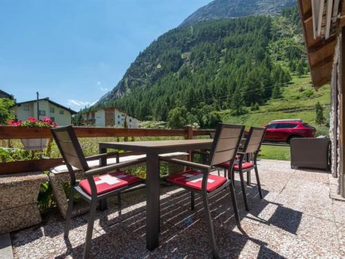 a table and chairs with a view of a mountain at Apartment Haus Adora by Interhome in Saas-Almagell