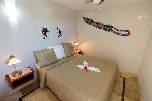 a bedroom with a bed with a flower on it at Seaside Apartment Flamingo in Kralendijk