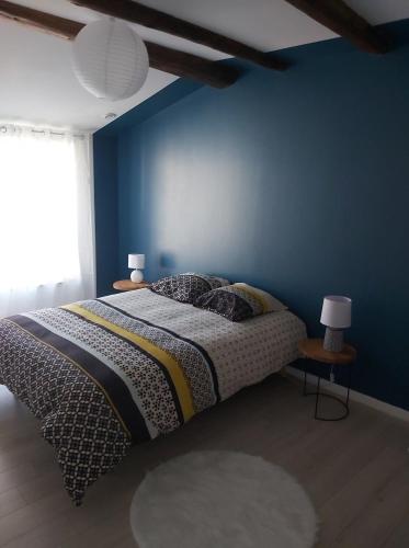 1 dormitorio con 1 cama con pared azul en La Tanière en Sorcy-Saint-Martin