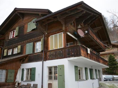 グスタードにあるApartment Oehrli by Interhomeのバルコニー付きの大きな木造家屋