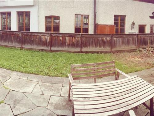 um banco de madeira sentado em frente a uma cerca em Apartment Oehrli by Interhome em Gstaad