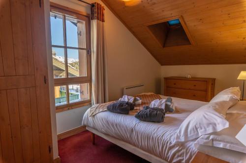 a bedroom with a bed with two bags on it at Bel Appartement spacieux 65m2 Les Arcs 1950 in Arc 1950