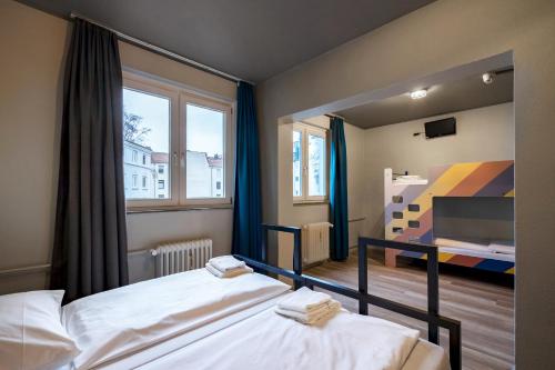 a bedroom with two beds and a large mirror at a&o Hamburg Reeperbahn in Hamburg