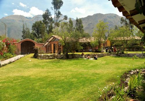 un gruppo di persone sedute sull'erba in un cortile di Andean Wings Valley a Urubamba