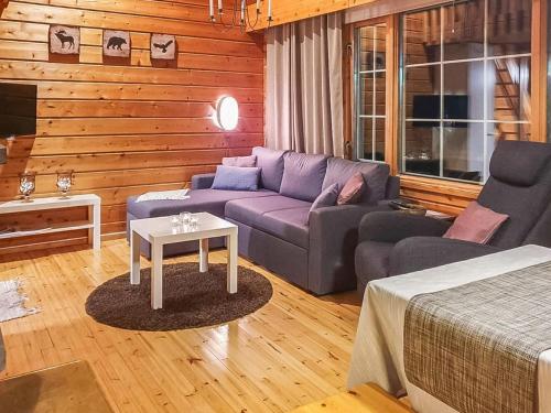ein Wohnzimmer mit einem lila Sofa und einem Tisch in der Unterkunft Holiday Home Kolonen by Interhome in Levi
