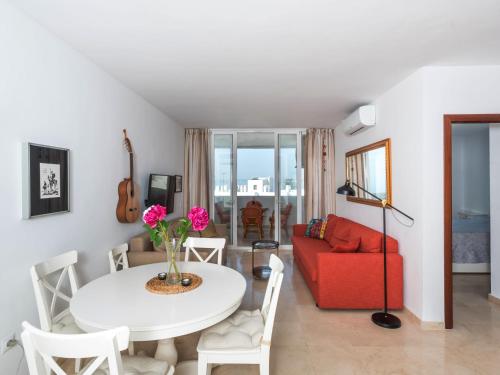 a living room with a table and a red couch at Apartment Carmen Vistamar by Interhome in Estepona