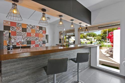 a bar with two chairs in front of a counter at Prado Villas in Vilamoura