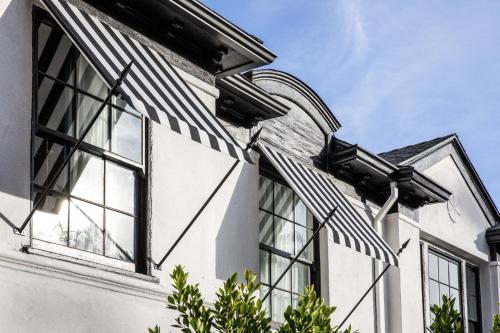 a house with a black and white striped awning at The Prospect Hollywood in Los Angeles