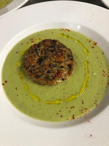 a bowl of soup with a piece of food in it at Logis Hôtel Restaurant Les Aubuns in Caissargues