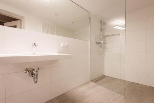 y baño blanco con lavabo y ducha. en Bliesransbacher 8 en Saarbrücken