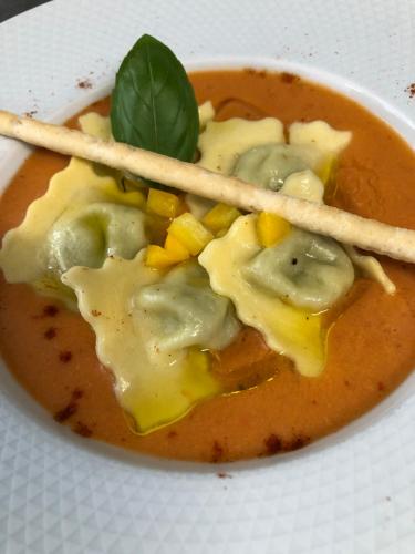 a bowl of soup with bamboo sticks in it at Logis Hôtel Restaurant Les Aubuns in Caissargues