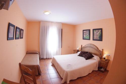 een slaapkamer met een wit bed en een raam bij Hotel Casa Duaner in Guardiola de Berguedà