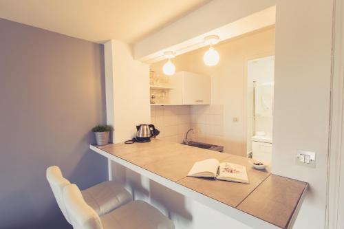 a kitchen with a counter with a book on it at La Maison de la Liberté Studio Jules Verne in Poitiers