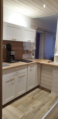 une cuisine avec des armoires blanches et un comptoir dans l'établissement Résidence le Galaxie, à Villard-de-Lans