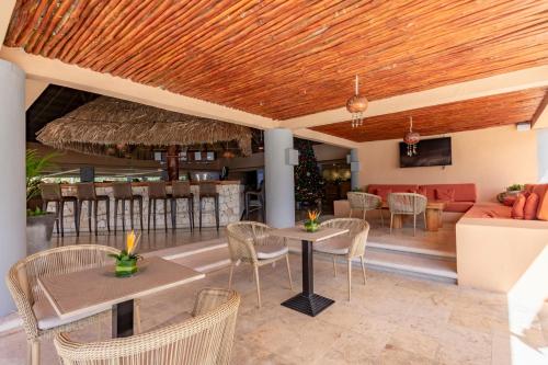 
a patio area with chairs, tables, and umbrellas at Puerto Aventuras Hotel & Beach Club in Puerto Aventuras
