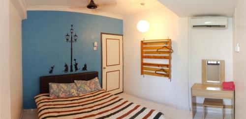 een slaapkamer met een bed met een blauwe muur bij DT Homestay floor level 4 in Melaka