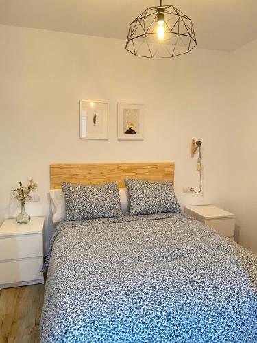 Un dormitorio con una cama con un edredón azul. en Nova Domus Apartamentos, en Mérida